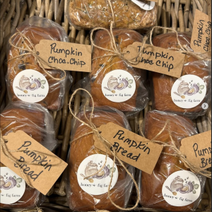 photo of loaves of sweet breads in a basket in plastic packaging with labels and each bearing a "honey + fig farm" logo sticker