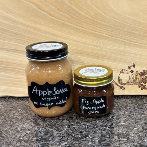 photo of two jars on a counter, one is the no sugar added organic apple sauce and the other is fig and apple pomegranate jam