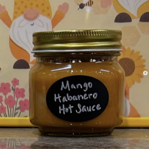 Photo of a tasting jar of Mango Habanero Hot Sauce sitting on a kitchen counter