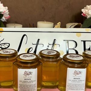 photo of five full smallest size of honey jars from "honey + fig farm" in front of a sign that says "Let it Bee"